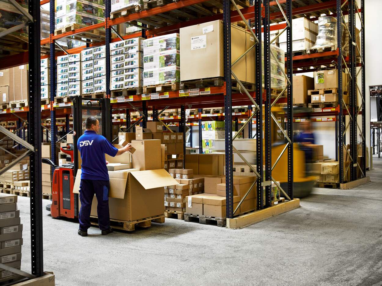 DSV medarbeider pakker og plasserer esker på lagerreoler